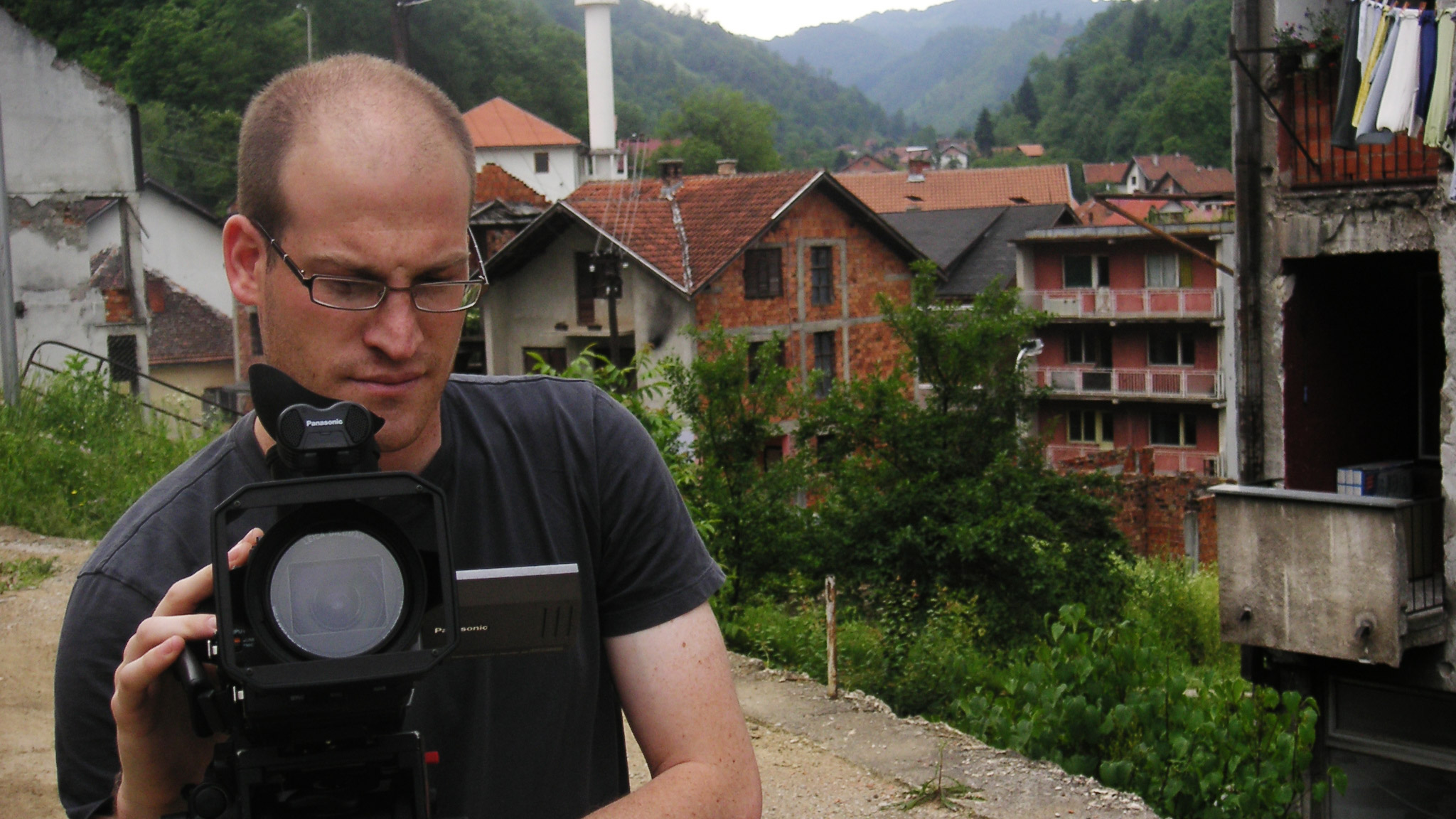 Student filming in a village